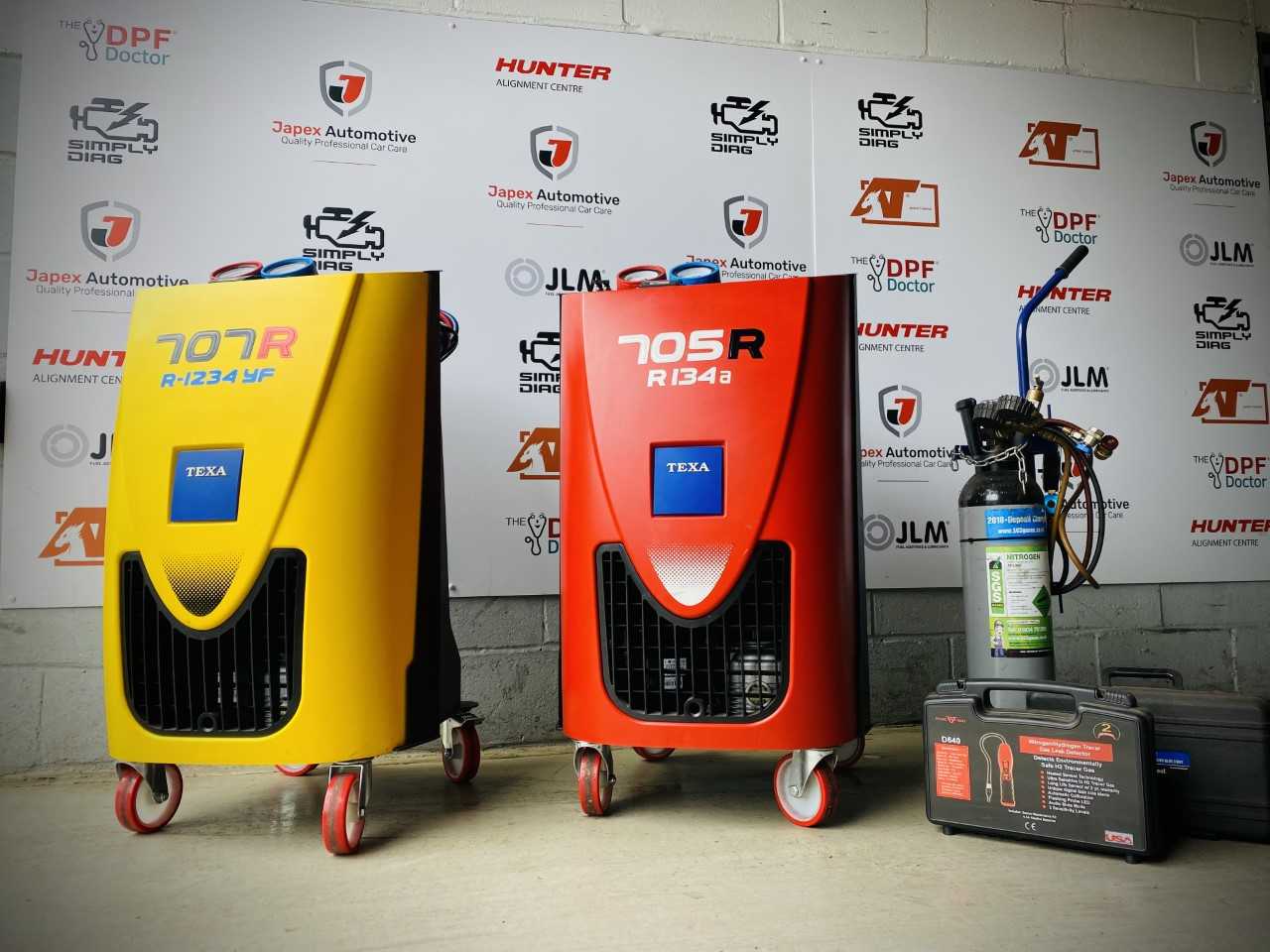 Car air-con machines. One yellow, one red, and one in grey, orange, and blue.